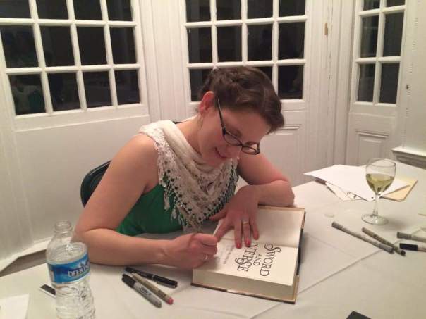 The author hard at work signing guests' copies of SWORD AND VERSE.