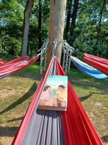 GIVE ME A SIGN lying in a hammock at camp.